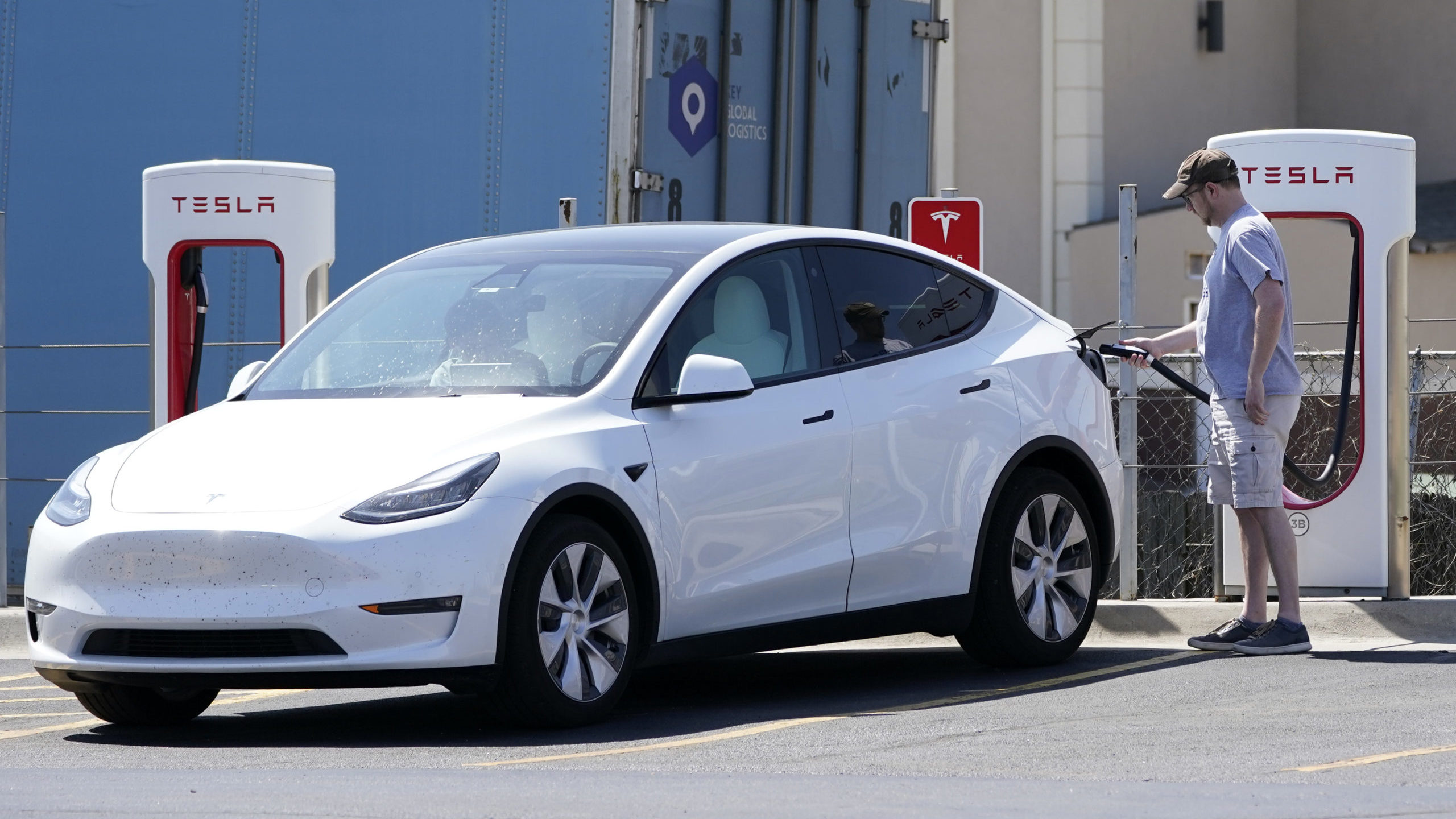 FILE - A Tesla owner charges his vehicle at a charging station in Topeka, Kan., Monday, April 5, 20...