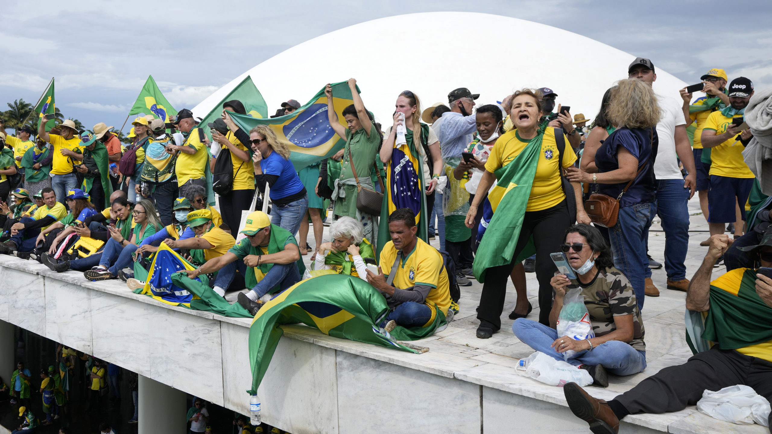 FILE - Protesters, supporters of Brazil's former President Jair Bolsonaro, stand on the roof of the...