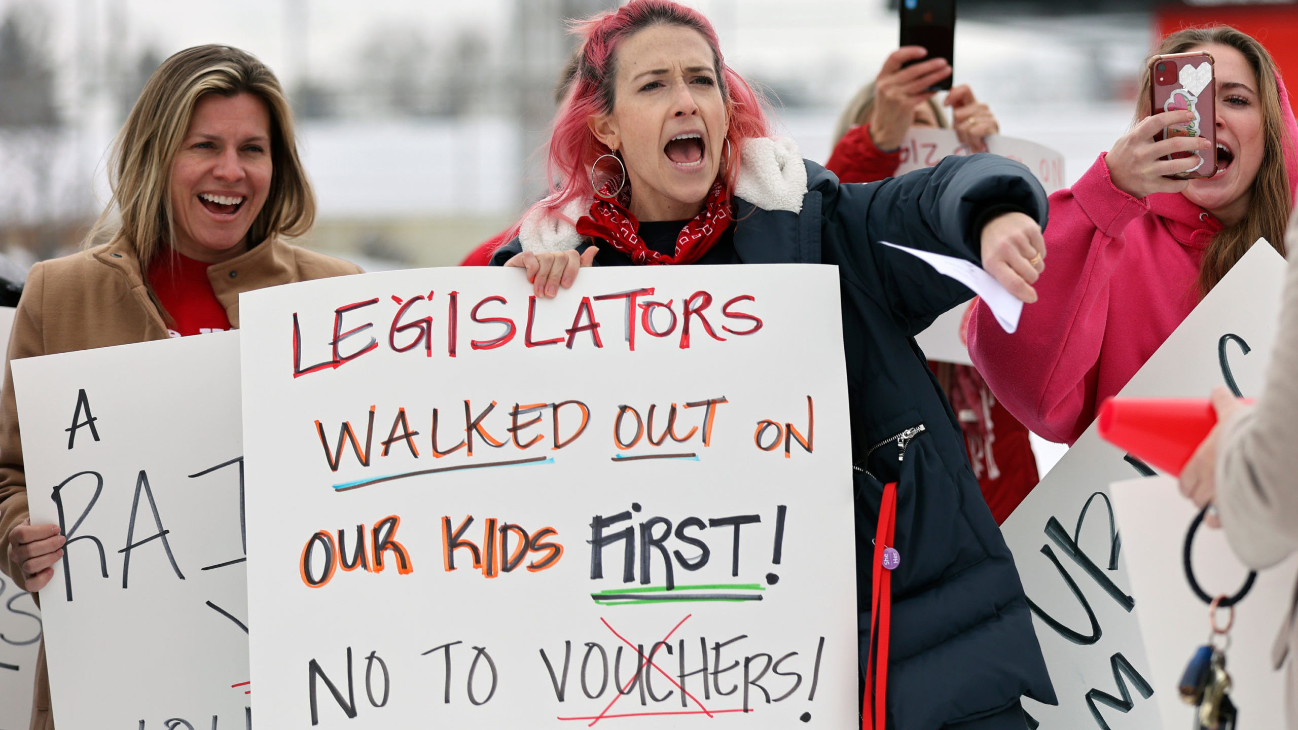 East High School teacher Elyse Arrington, center, cheers during a teacher and student walkout prote...