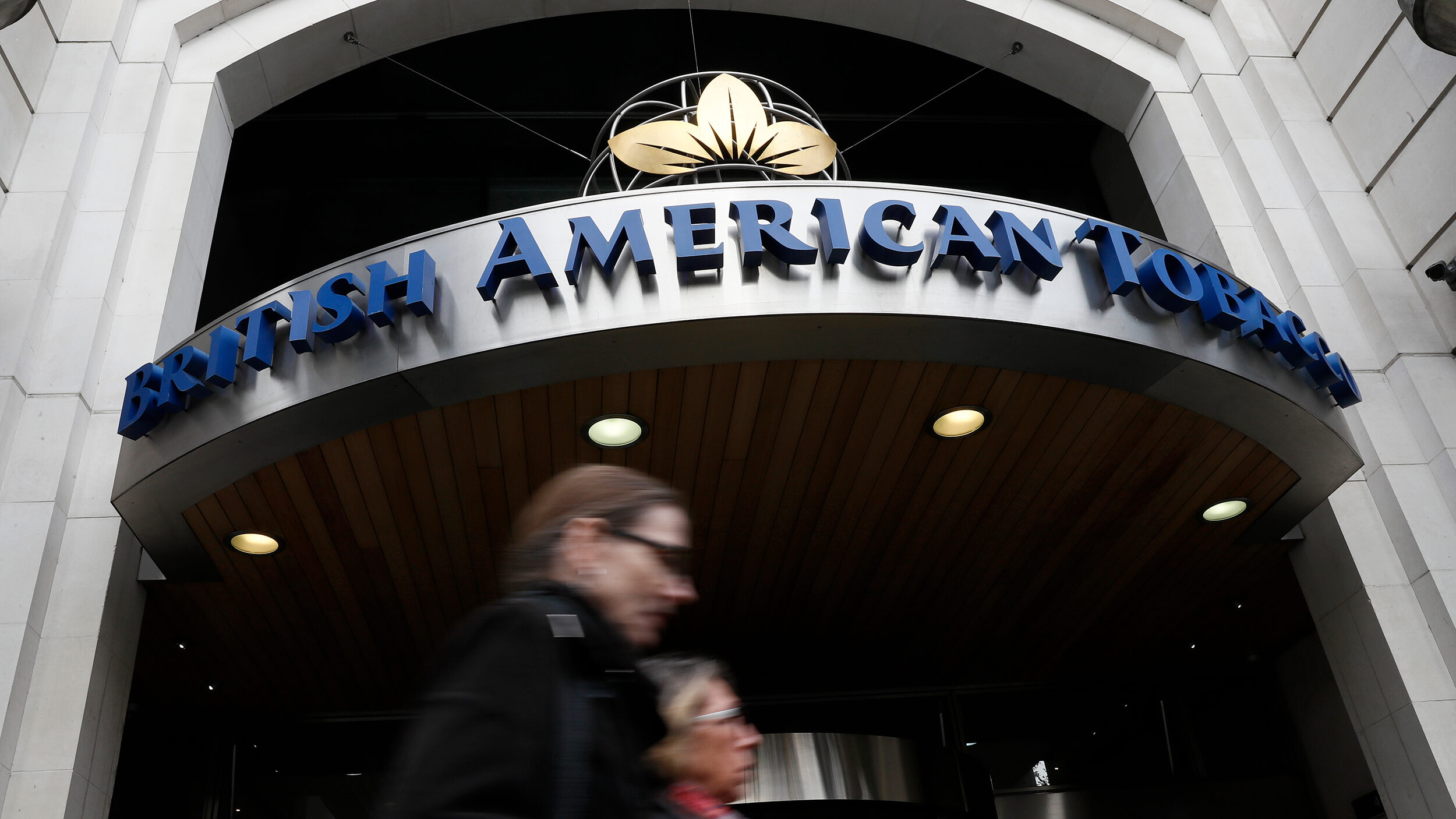 People walk past the British American Tobacco offices in London, Britain October 21, 2016. REUTERS/...