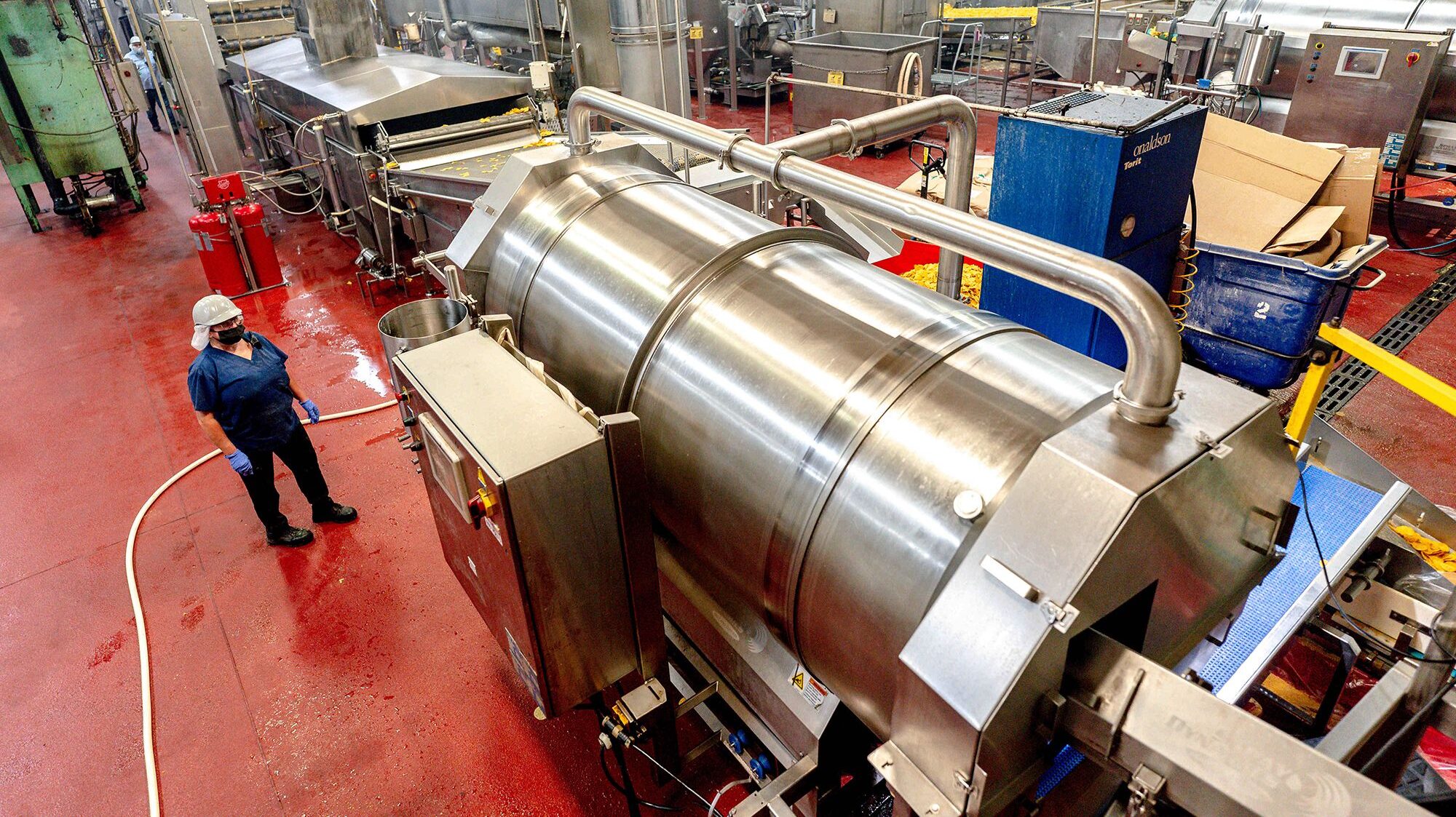 a person is pictured next to machinery in a factory...