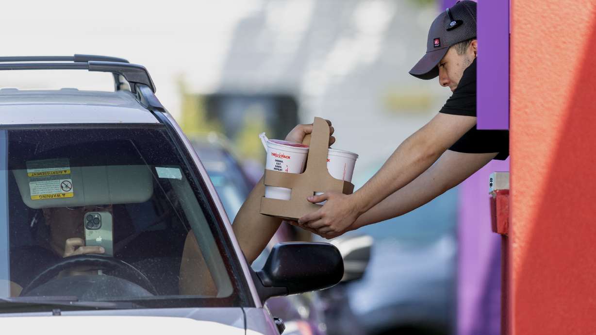 Image of a fast food employee handing a customer their meal. This week, Salt Lake City officials vo...
