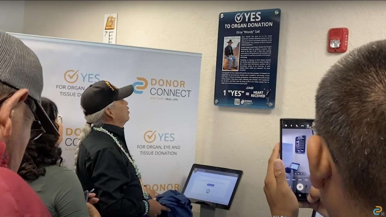heart recipient elroy salt looks at a plaque made in his honor, several other plaques honoring dono...