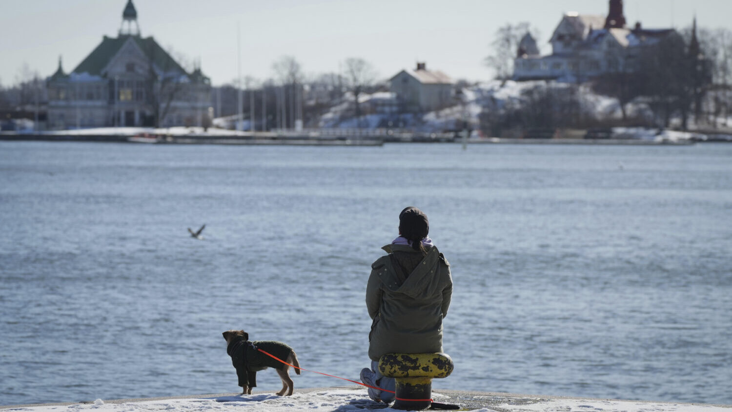 A woman enjoys a sunny and frosty day on the embankment of the South Harbour in Helsinki, Finland, ...