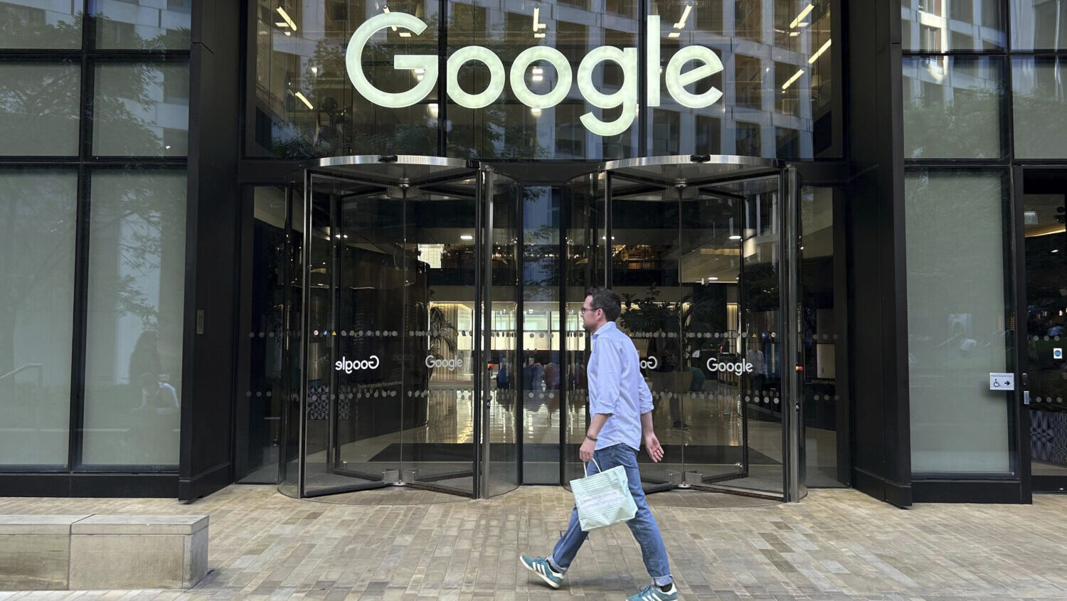 FILE - A man walks past Google's offices in London's Kings Cross area, on Aug. 10, 2024....