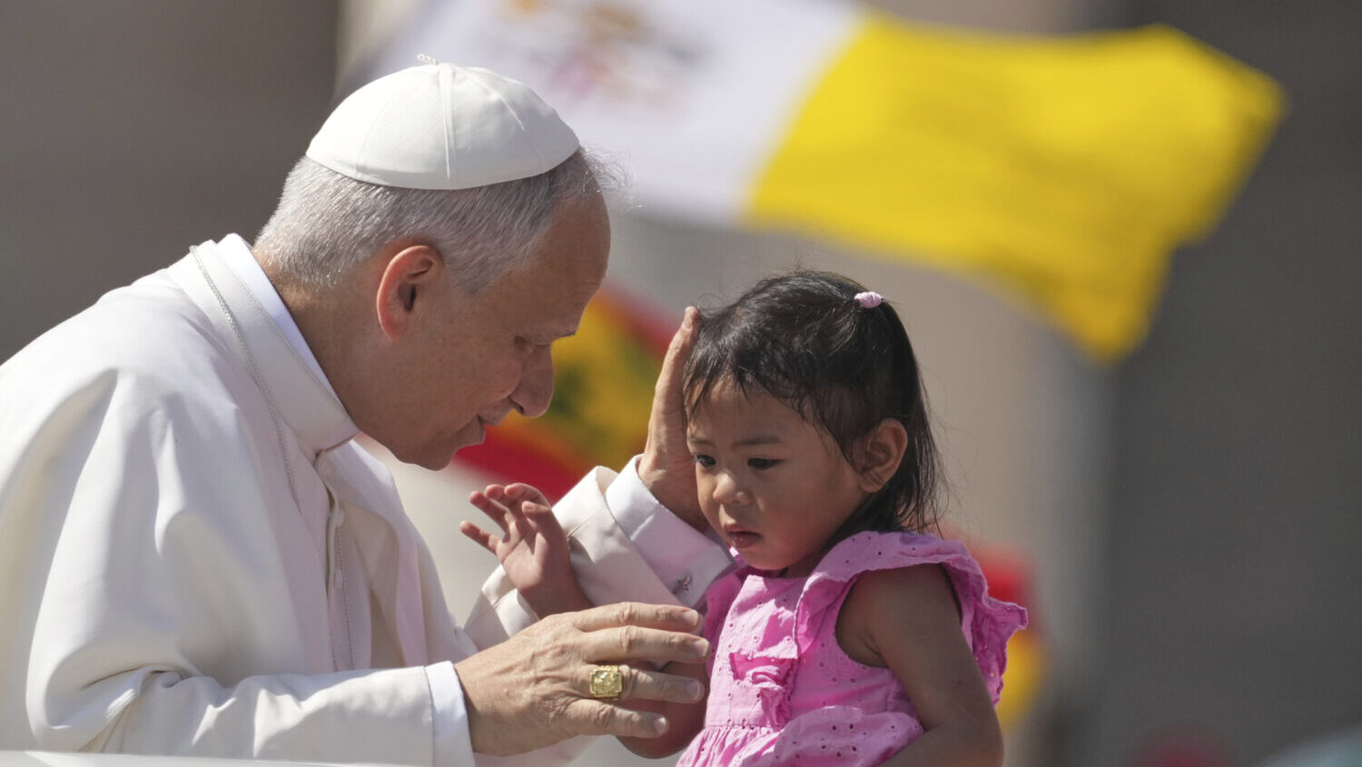 Pope Leo XIV caresses a little girl...