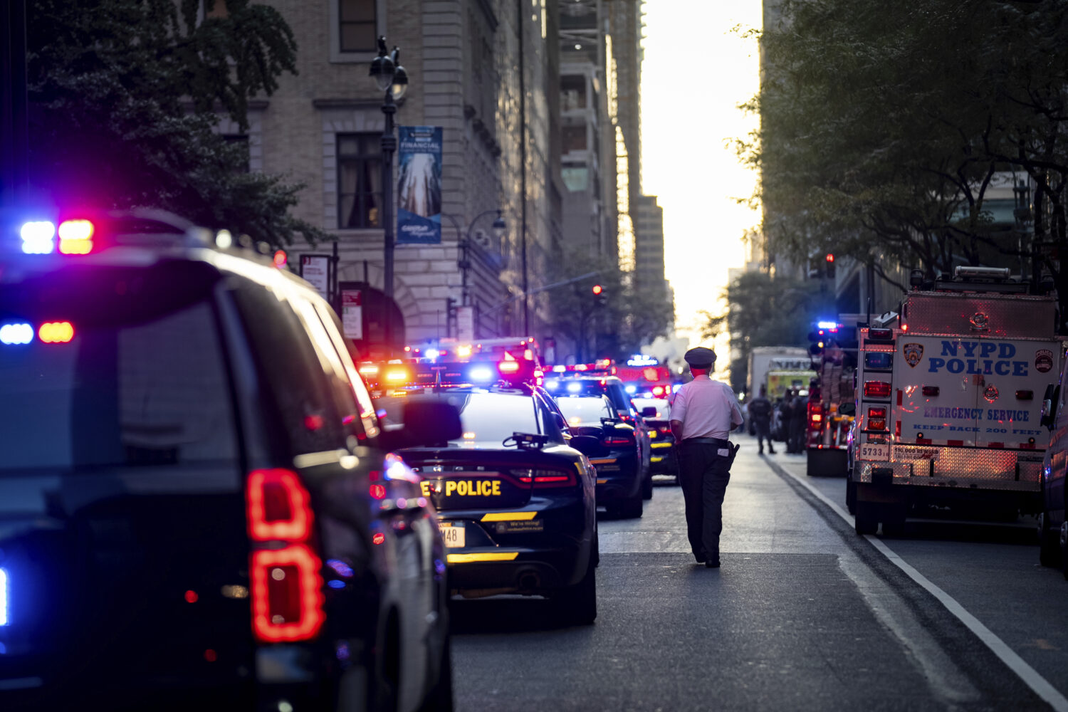 A New York police officer stands watch on 52nd Street outside a Manhattan office building where at ...