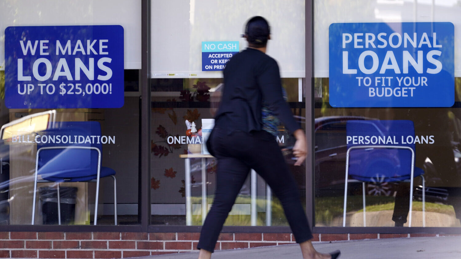 FILE - A woman walks past a personal finance loan office Thursday, Oct. 1, 2020, in Franklin, Tenn....