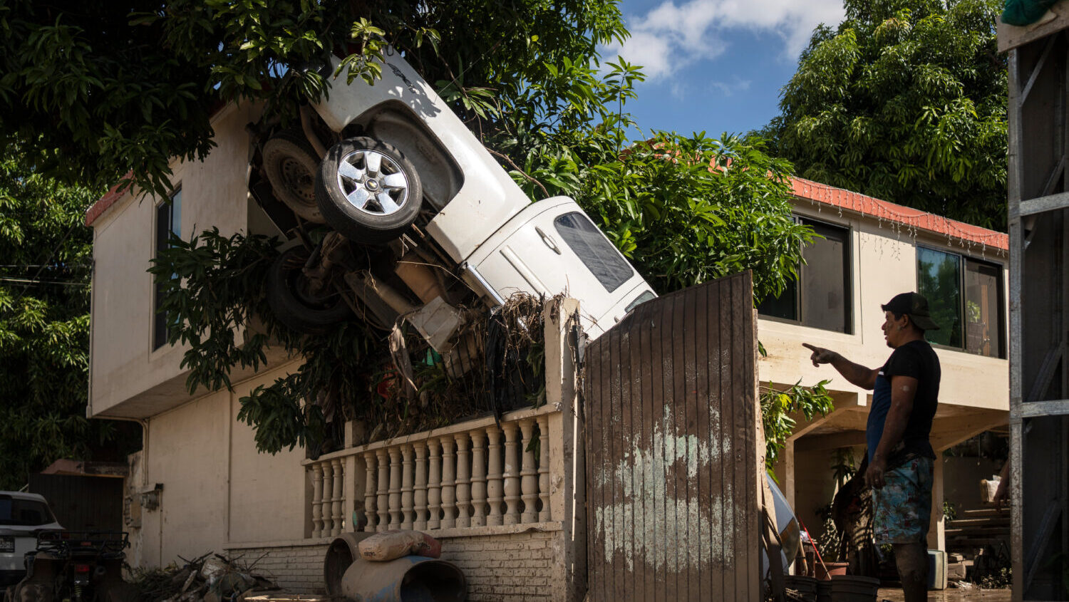 A pickup truck hangs over a fence in Poza Rica, Veracruz state, Mexico, Sunday, Oct. 12, 2025, afte...