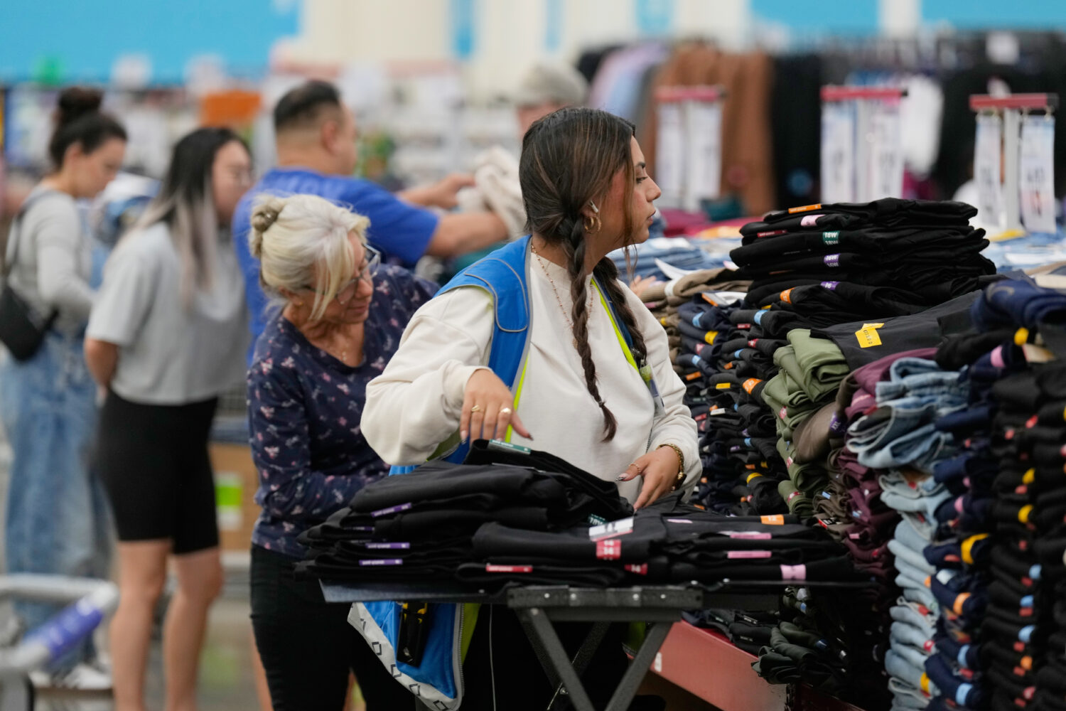 A worker stocks a display of clothing at a Sam's Club, Wednesday, Sept. 24, 2025, in Bentonville, A...