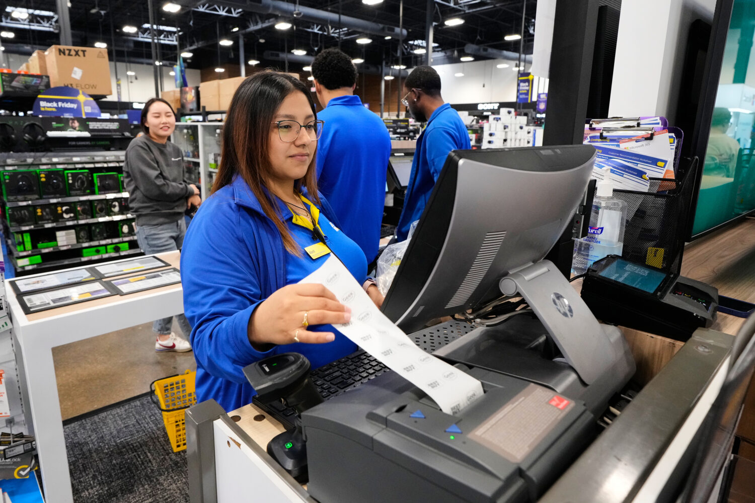 Abril Renteria, an Apple certified advisor, helps a customer check out after their purchase at a Be...