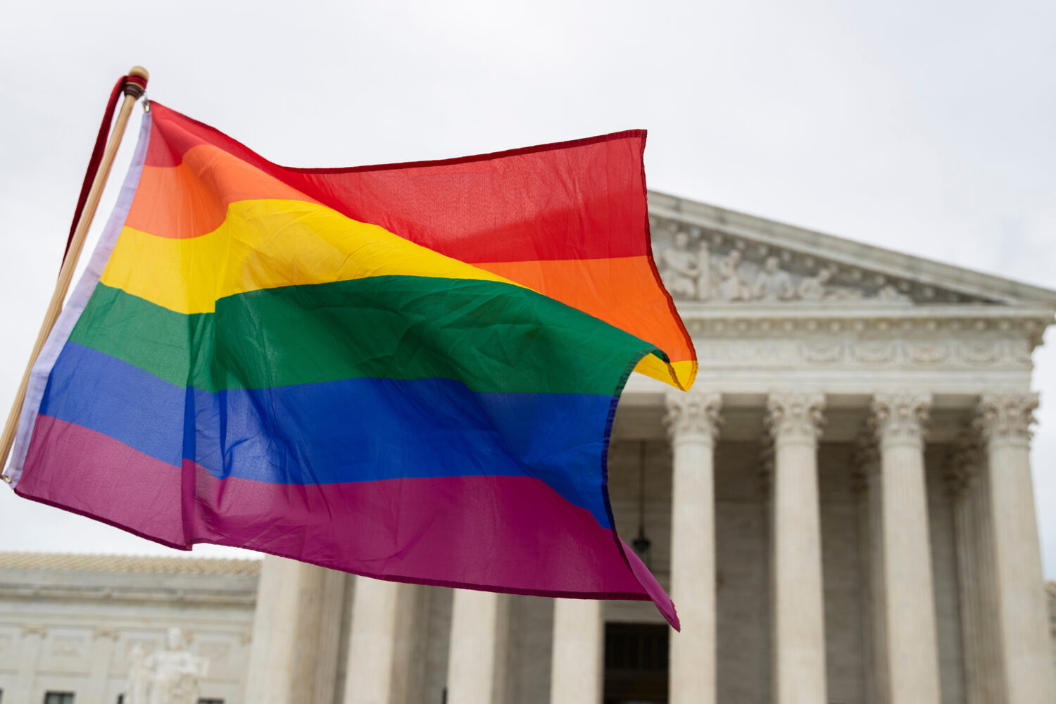 FILE - Supporters of the LGBT wave their flag in front of the U.S. Supreme Cour, Oct. 8, 2019, in W...
