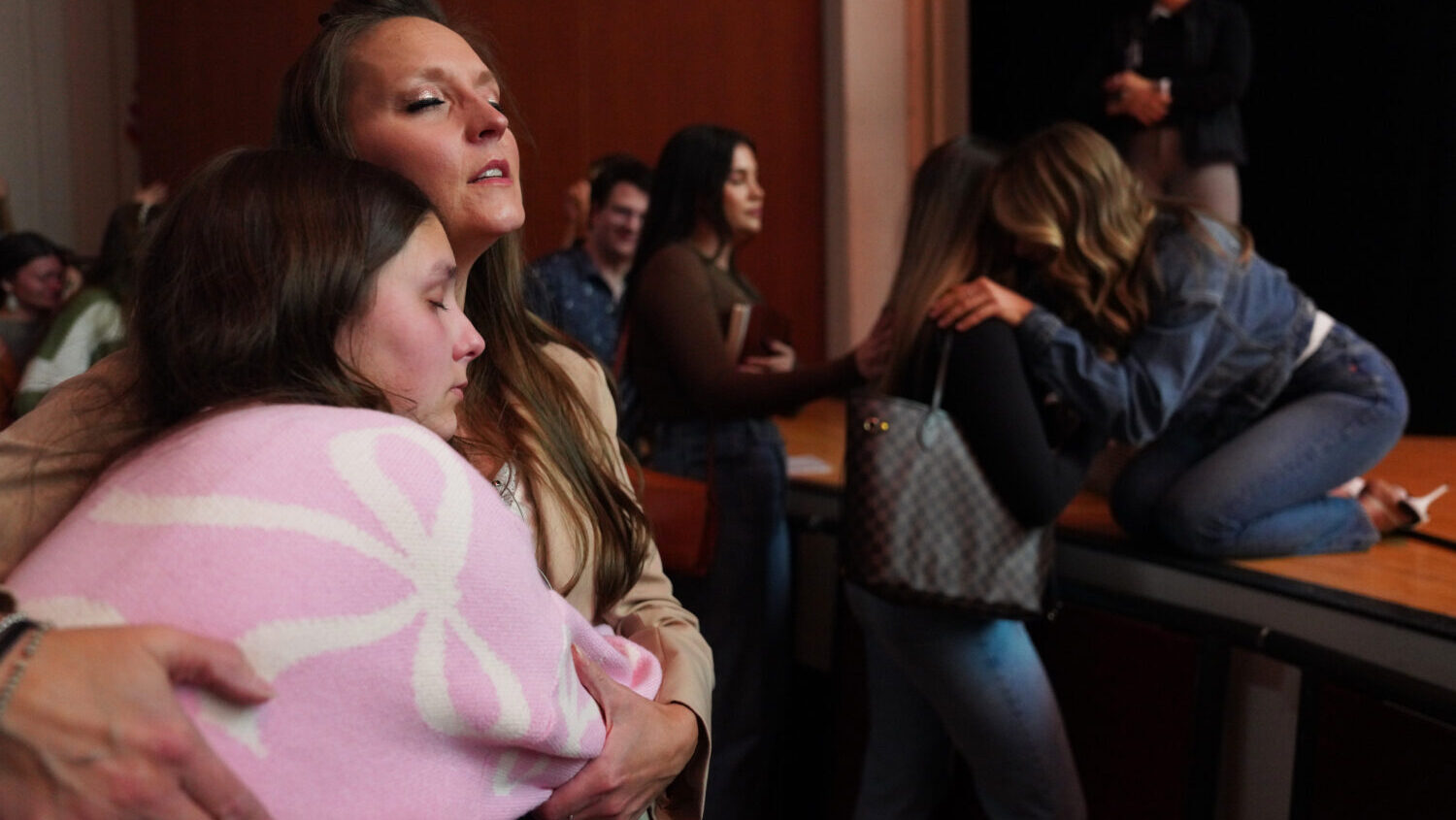 Angela Halili, 29, right, cohost of the Christian podcast, "Girls Gone Bible," prays over a followe...