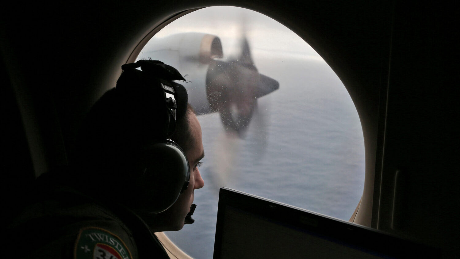 FILE - Flight officer Rayan Gharazeddine scans the water in the southern Indian Ocean off Australia...
