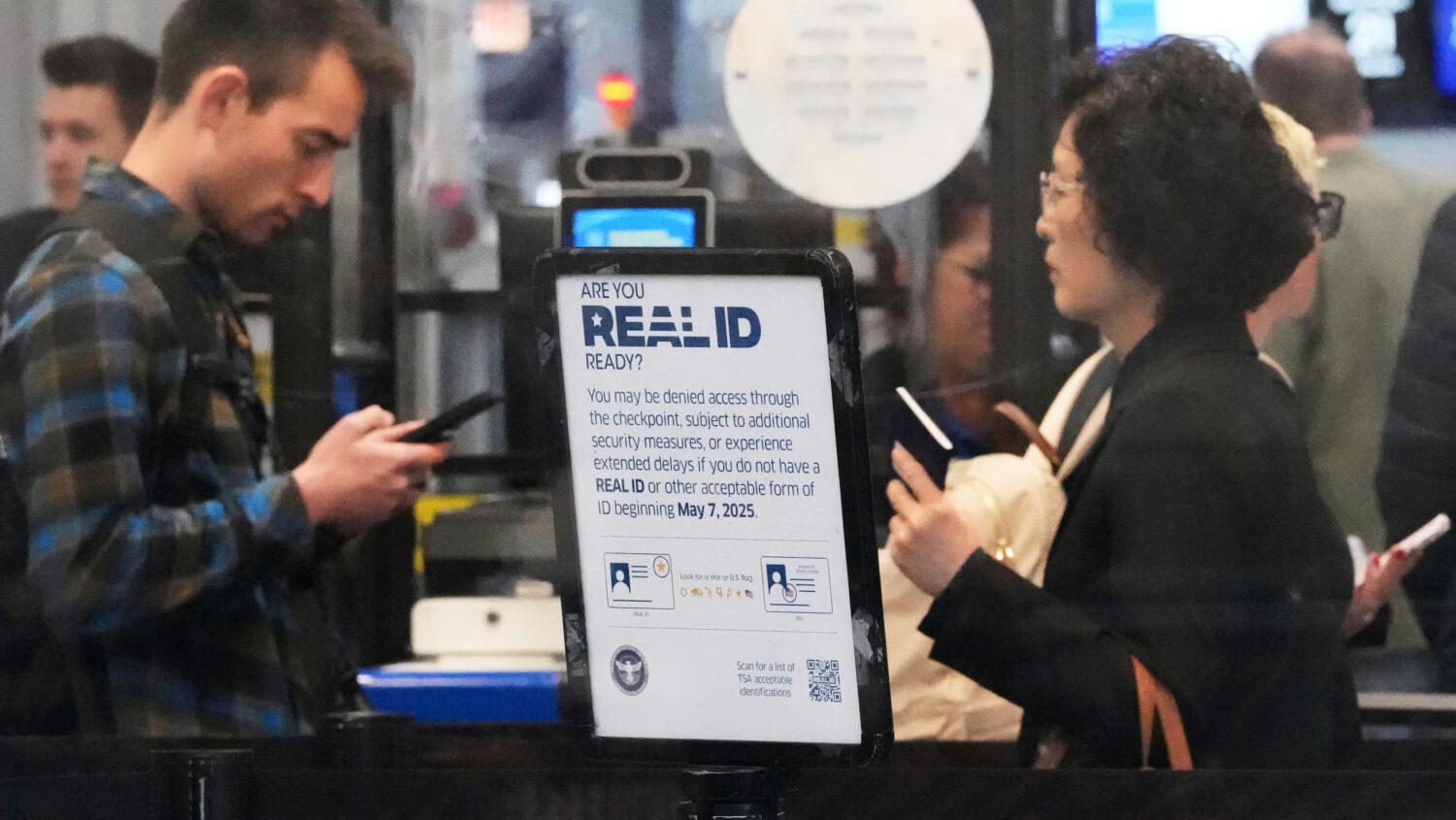 FILE - A Real ID sign is displayed as travelers wait to go through security check point at O'Hare I...