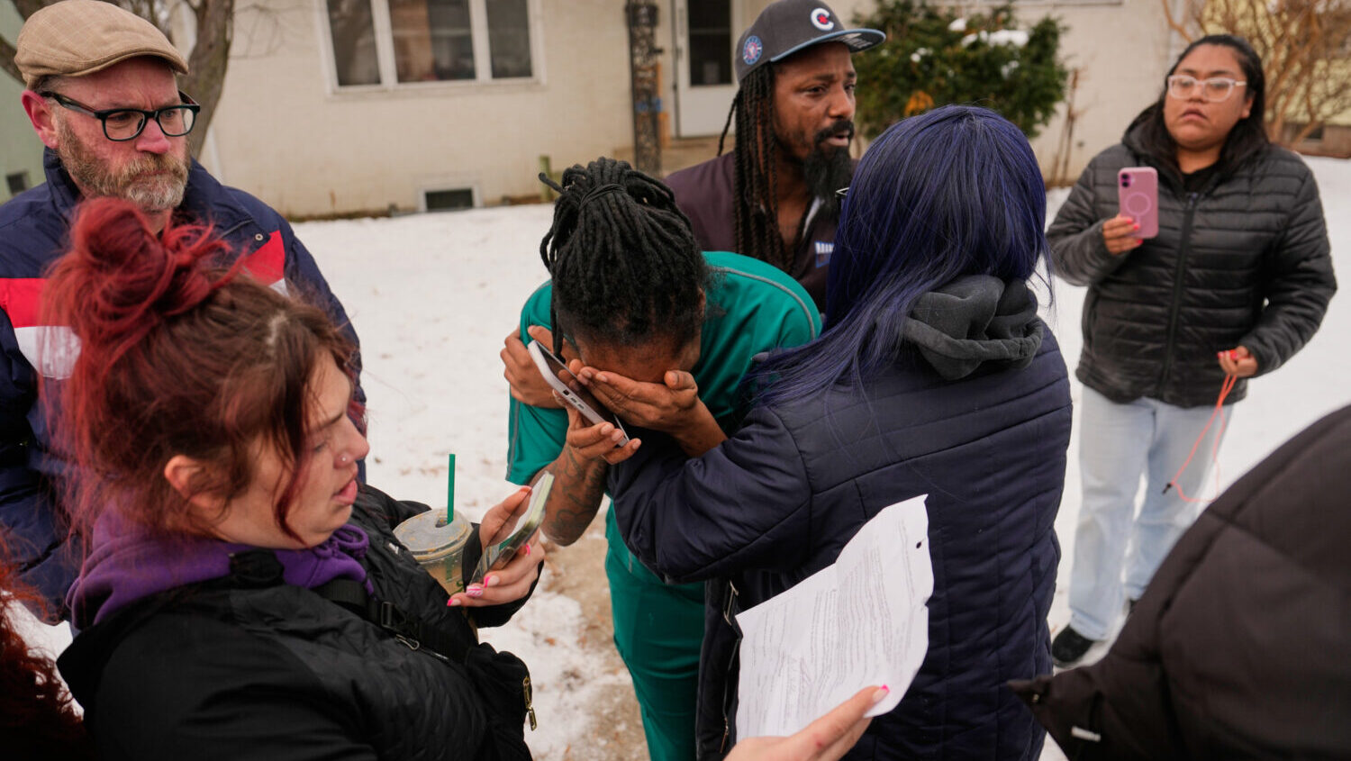 A family member, center, reacts after federal immigration officers make an arrest Sunday, Jan. 11, ...