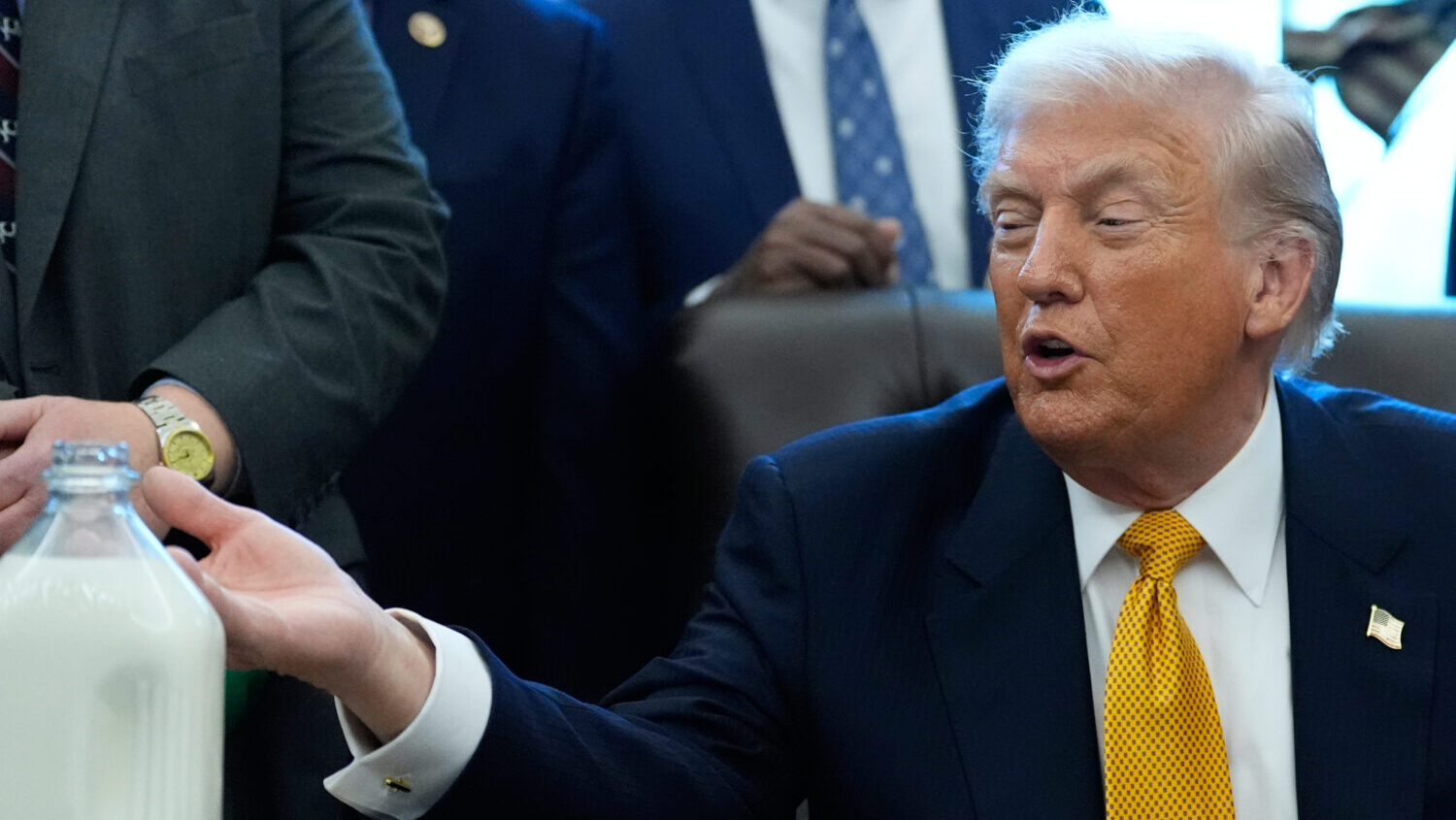 President Donald Trump gestures to a container of milk before he signs a bill that returns whole mi...