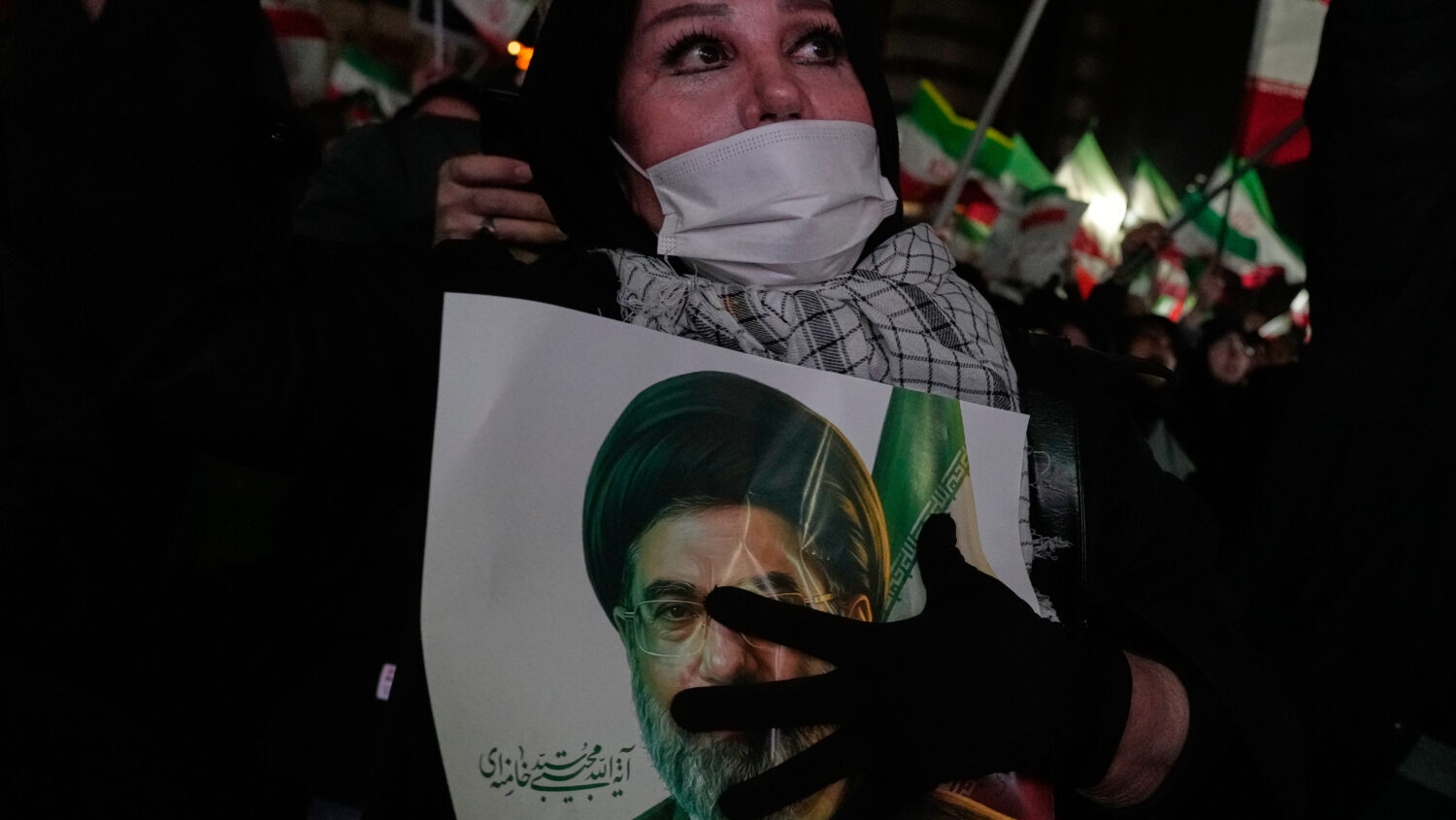 A woman holds a picture of the Iranian Supreme Leader Ayatollah Mojtaba Khamenei during a pro-gover...