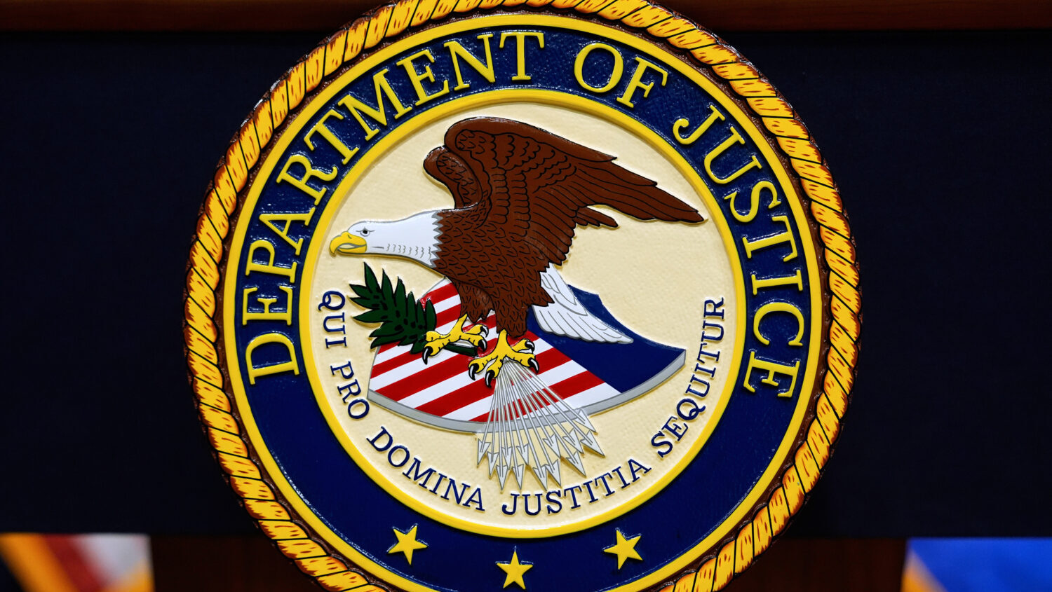 The U.S. Department of Justice logo is seen on a podium before a press conference, May 6, 2025, at ...