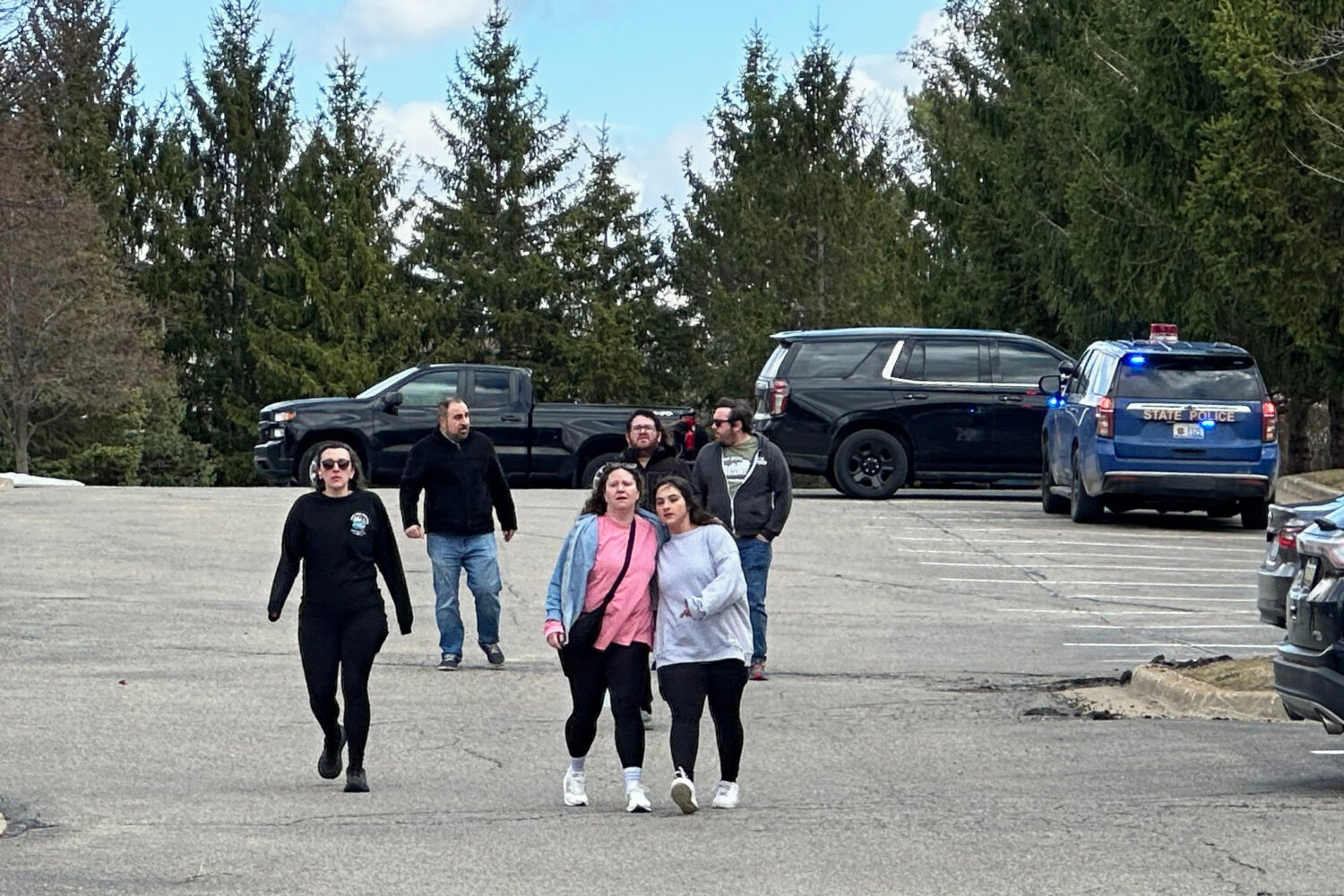 People gather near Temple Israel synagogue in West Bloomfield Township, Mich....