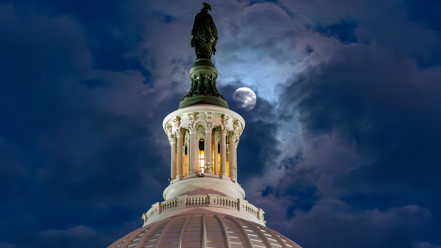 FILE - The moon emerges from the clouds over the U.S. Capitol dome in Washington, Dec. 2, 2025....