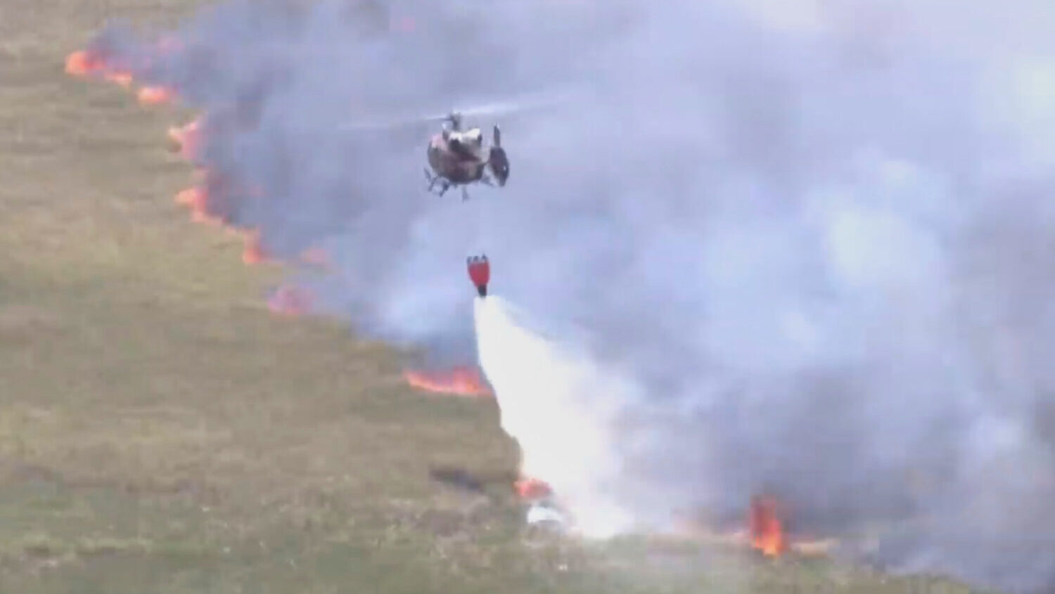This image taken from a WSVN video shows firefighters battling a wildfire Wednesday, April 22, 2026...