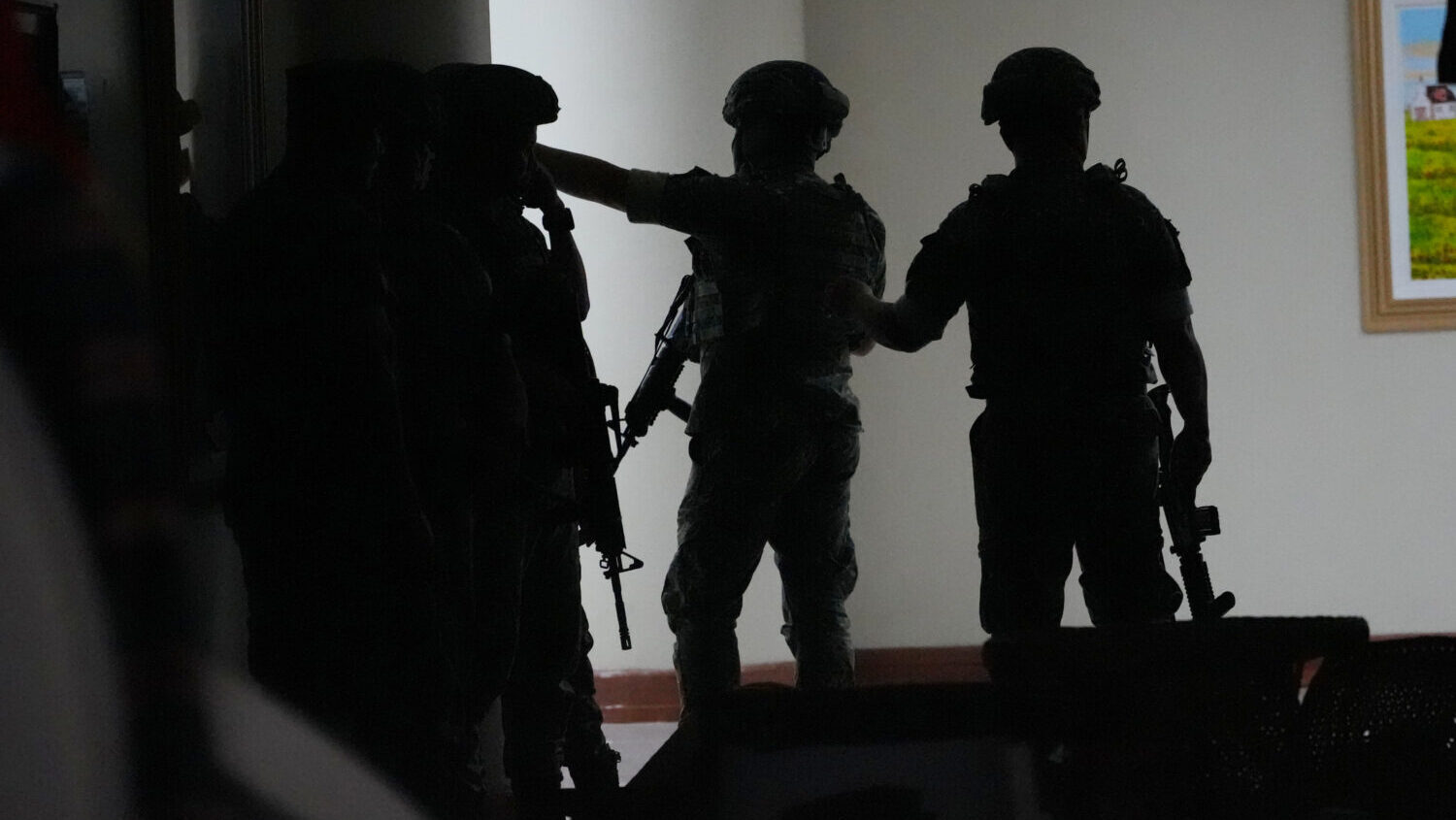 Philippine troopers exchange fire along a hallway at the Philippine Senate in Pasay, Philippines on...