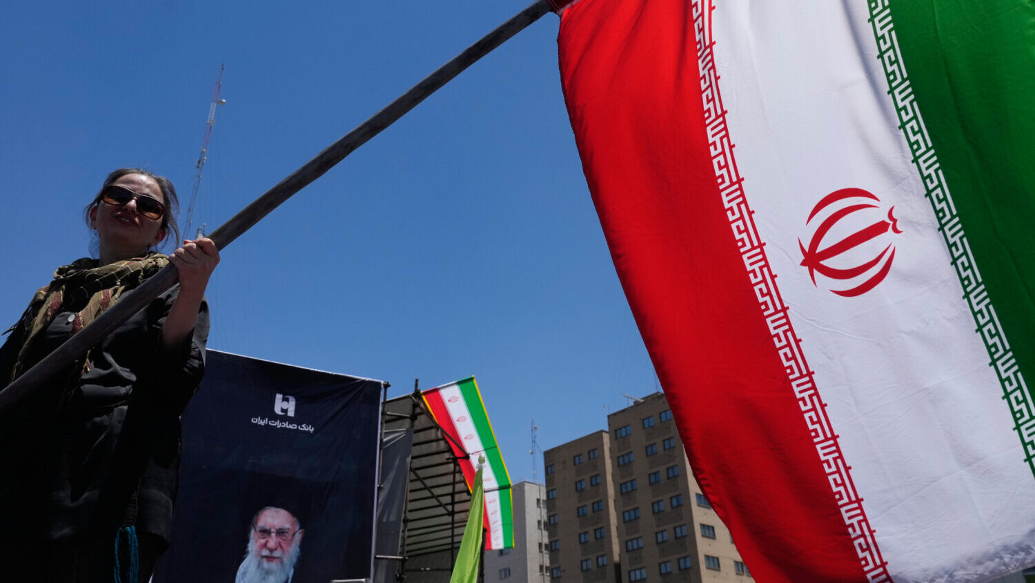 A woman waves an Iranian flag during a pro-government campaign in Tehran, Iran, Monday, June 15, 20...